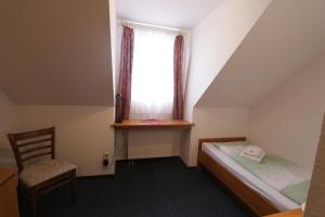 niewielka sypialnia z łóżkiem i oknem w obiekcie Hotel Riedel w mieście Żytawa