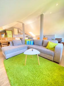 ein Wohnzimmer mit einem Sofa und einem grünen Teppich in der Unterkunft FeWo Sulzer Siedlung Erfurt in Erfurt