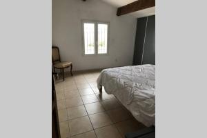 a bedroom with a bed and a tiled floor at Maison spacieuse in Gruissan