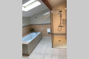 a bathroom with a bath tub and a shower at Maison spacieuse in Gruissan +9 photos