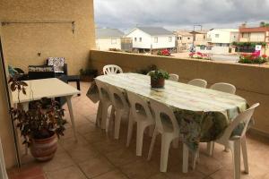 a table and chairs on a balcony with a view at Maison spacieuse in Gruissan