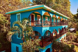 烏提拉的住宿－MANURII Garden，前面有棕榈树的蓝色房子