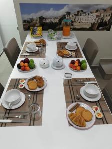 un lungo tavolo con piatti di cibo sopra di Casa Vacanze Civico 32 a Montescaglioso