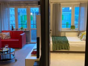 a living room with a red couch and windows at Good Time Apartments - Warsaw Zgoda in Warsaw