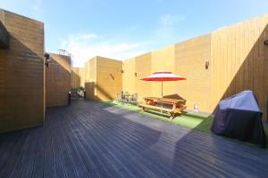 a wooden deck with a picnic table and an umbrella at The BS Hotel Busan Station in Busan