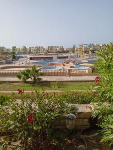 uma vista para um parque com flores e um parque infantil em R1 CH21 studio 2 beds poolside garden terrace Green Beach em El Alamein