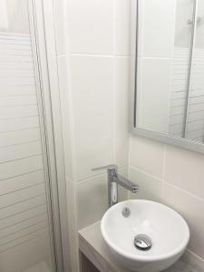 a bathroom with a white sink and a mirror at Lemon Hotel Plan de Campagne Marseille in Septèmes-les-Vallons +5 photos