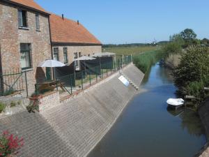 a building and a river next to a house at Vakantiewoningen t-dorp in Meetkerke