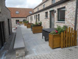 a courtyard with a row of tables and potted plants at Vakantiewoningen t-dorp in Meetkerke