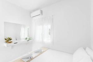 a white room with a bed and a mirror at Family Maisonette with pool #2 in Nea Fokea +30 photos