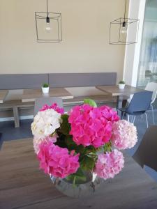 eine Vase voller rosa und weißer Blumen auf dem Tisch in der Unterkunft Albergo Garni Francesco in Nago-Torbole