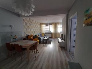 ein Wohnzimmer mit einem Tisch und einem Sofa in der Unterkunft Domki i apartamenty w Ustroniu Morskim in Ustronie Morskie