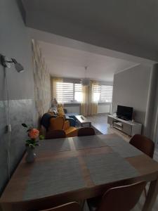 uma sala de estar com uma mesa e um sofá em Domki i apartamenty w Ustroniu Morskim em Ustronie Morskie