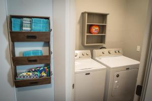 eine Waschküche mit einem Waschbecken und einer Waschmaschine in der Unterkunft The Cozy, Fiber Internet, Roku TVs, Washer & Dryer, Near DT Chickasha & Leg Lamp! in Chickasha