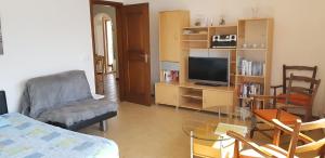 ein Wohnzimmer mit einem TV und einem Glastisch in der Unterkunft Santa Maria Ferienwohnung in Ronco sopra Ascona