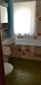 a bathroom with a tub and a sink and a window at Santa Maria Ferienwohnung in Ronco sopra Ascona