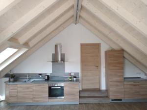 an attic kitchen with wooden cabinets and a stove at Ferienwohnung Regina in Berching