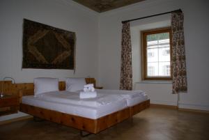 a bedroom with a large white bed with a window at Historisches Hotel Piz Ela Bergün in Bergün