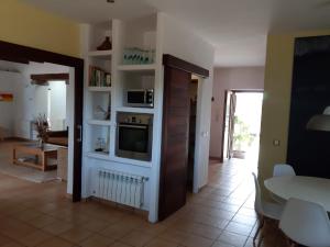 a living room with a television and a living room with a table at Sa Vinyeta in Sant Llorenç de Balafia