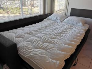 Cette chambre comprend un grand lit blanc et une fenêtre. dans l'établissement Ylläs Kanerva 108, à Ylläs