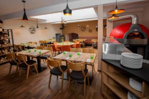 a restaurant with wooden tables and chairs and a kitchen at Apartmany Pisek in Písek