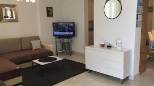 uma sala de estar com um sofá e uma televisão em Apartment Novi Vinodolski em Novi Vinodolski