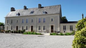 a large white house with a gray roof at Ferme du Rupalley in Isigny-sur-Mer