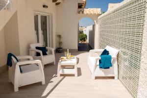 a patio with white wicker chairs and a table at Beach Villa Flamenca in Orihuela