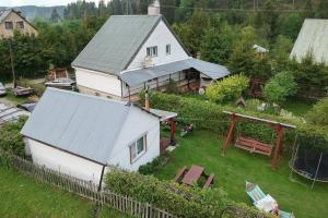 eine Luftansicht auf ein weißes Haus mit einem Hinterhof in der Unterkunft Bieszczady Smolnik Cottage in Smolnik