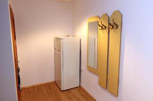 a room with a refrigerator and mirrors on the wall at Pokoje u flisaka in Krościenko