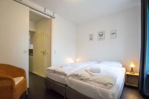 sypialnia z dużym łóżkiem z białą pościelą w obiekcie Old Town 2 Room Apartments w mieście Düsseldorf