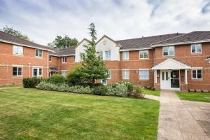 een groot bakstenen gebouw met een grasveld bij GF flat sleeps 4, parking for Contractors by Eagle Owl Stays in Crawley