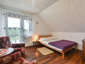 sypialnia z łóżkiem i kanapą w pokoju w obiekcie HarmoniaUrlopu w Polańczyku