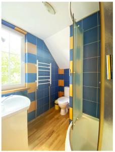 ein Bad mit einer Dusche, einem Waschbecken und einem WC in der Unterkunft Apartamentai Obelynė in Palanga