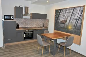 a kitchen with a table and a deer painting on the wall at Dom-i-Ziel Apartments in St. Blasien