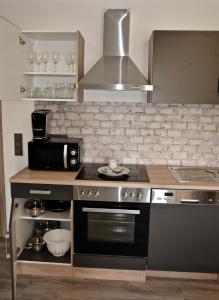 a kitchen with a stove and a microwave at Dom-i-Ziel Apartments in St. Blasien