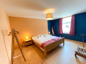 a bedroom with a bed with blue walls and a window at Madulain Lodge @ Werkhof in Madulain