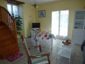 sala de estar con mesa y sillas en Gîte Le Logis de Faugerit, en Frontenay-Rohan-Rohan