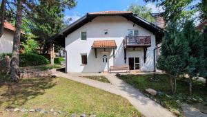Casa blanca con porche y balcón en Apartman Biljana, en Zlatibor