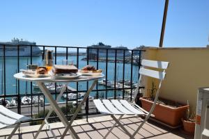 a table on a balcony with a view of a harbor at B&B Il Veliero in Civitavecchia