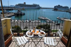 a table on a balcony with a view of a harbor at B&B Il Veliero in Civitavecchia