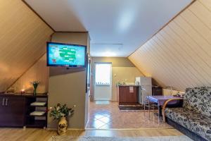 ein Wohnzimmer mit einem Sofa und einem Flachbild-TV in der Unterkunft Pensjonat Jagoda in Pisz