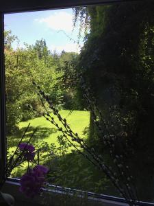 einen Blick auf den Garten von einem Fenster mit Blumen in der Unterkunft Feldstraße 10 in Lüneburg