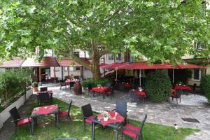 ein Restaurant im Freien mit Tischen und Stühlen unter einem Baum in der Unterkunft Hotel Payerbacherhof in Payerbach
