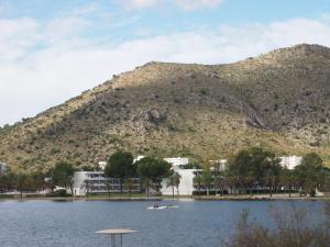 a mountain with two people in a boat on a lake at Chalet Llac in Port d'Alcudia