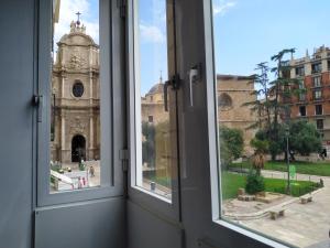 une fenêtre ouverte avec vue sur une église dans l'établissement Flats Friends Plaza de la Reina, à Valence