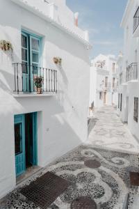 a street with white buildings and a tiled floor at Casa Calle Real 87 in Frigiliana