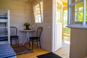 パルティスキにあるPakri poolsaare matkaplatsのテーブルと椅子2脚が備わる小さな客室です。