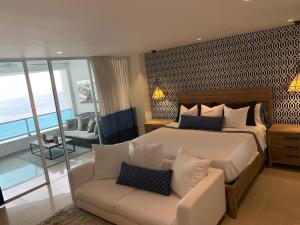 サントドミンゴにあるLuxury penthouse portobelloの大きなベッドとソファのある寝室