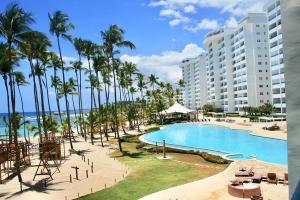 a view of a resort with a pool and palm trees at Luxury penthouse portobello in Villas del Mar